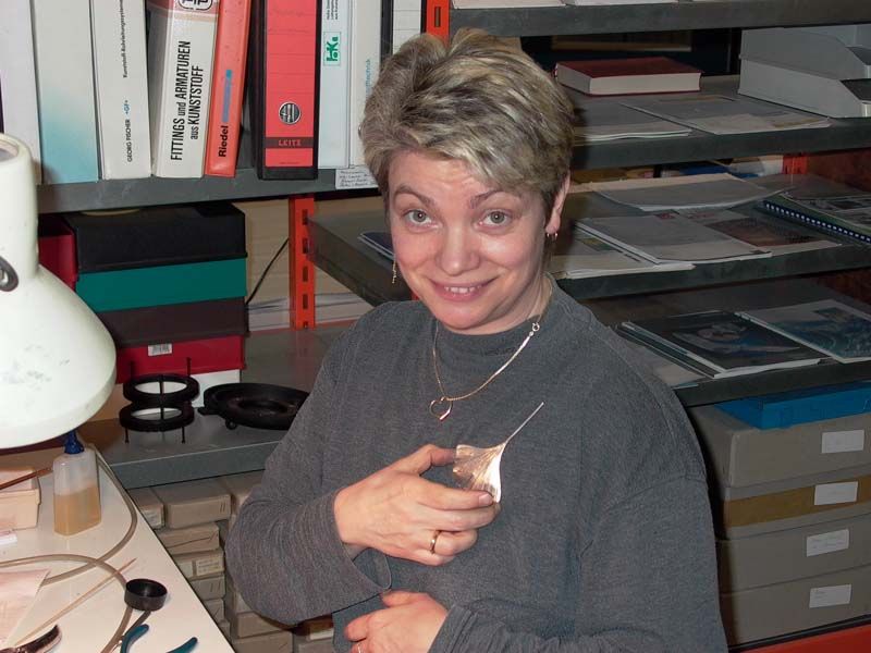 Frau zeigt Blatt als Schmuck