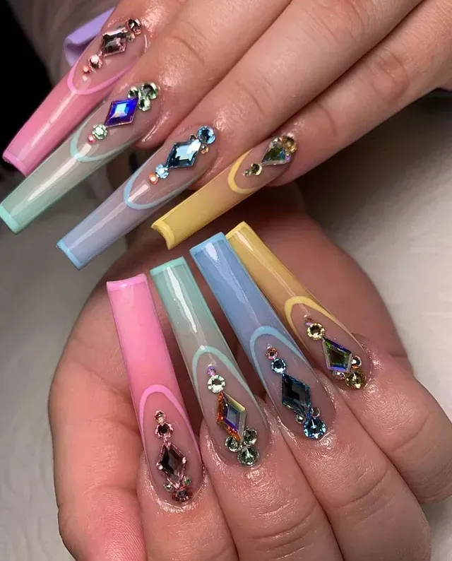 Un primer plano de la mano de una persona con uñas largas y diamantes de imitación.