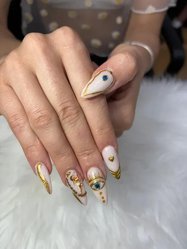 Un primer plano de las uñas de una mujer con un diseño de mal de ojo.