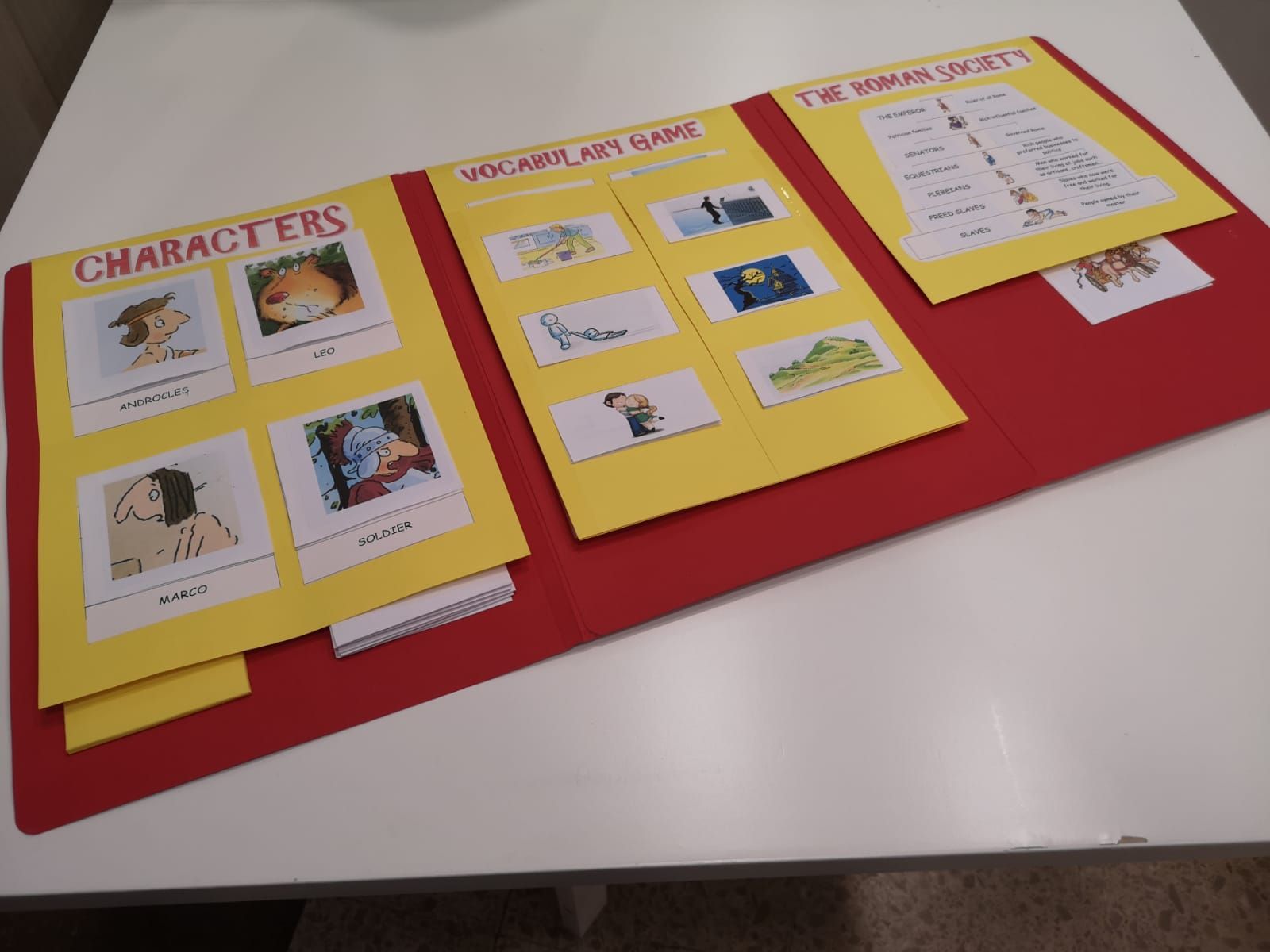 Una persona con una camisa azul levanta la mano en un aula con otros estudiantes y un profesor.