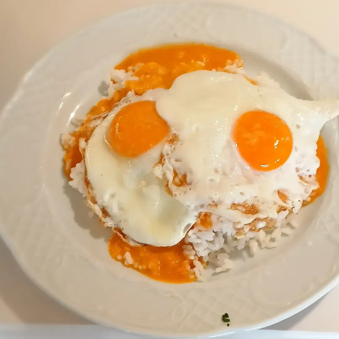 Un primer plano de un plato de comida con huevos y arroz.