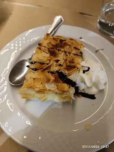 Hay un trozo de pastel en un plato con crema batida y una cuchara.