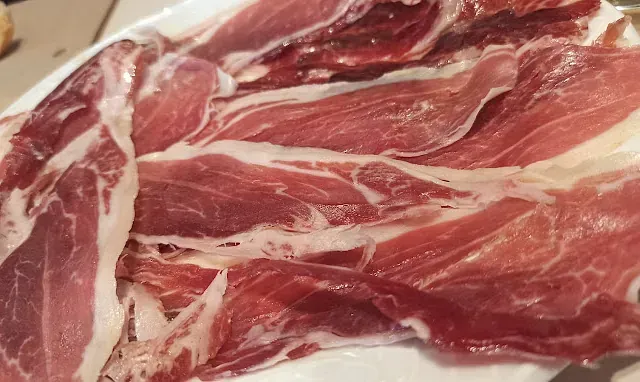 Un primer plano de un plato de carne sobre una mesa.