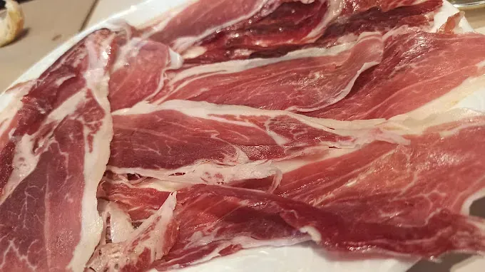 Un primer plano de un plato de carne sobre una mesa.