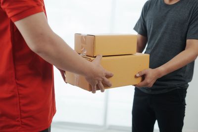 Ein zweistöckiges, im Bau befindliches Haus mit beiger Fassade und braunem Dach vor strahlend blauem Himmel.