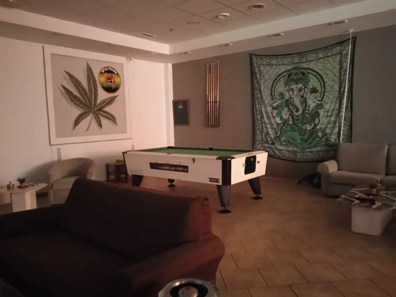 Mesa de billar en una habitación con un sofá.