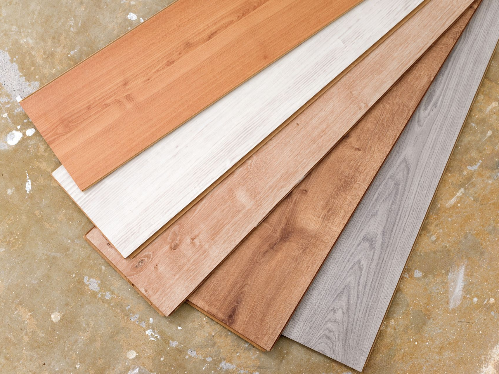 Planches de bois de couleurs variées disposées sur une surface beige.