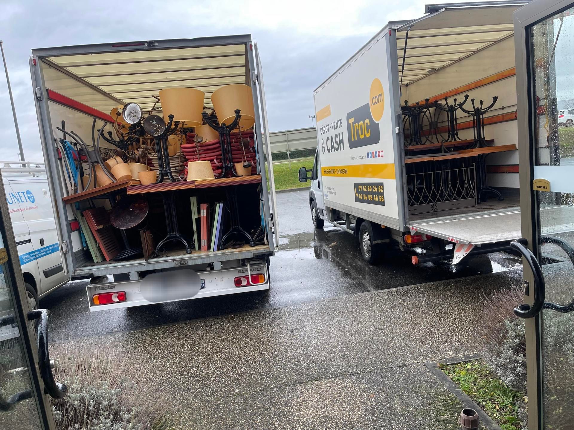 Deux camions de déménagement chargés de meubles sont stationnés.