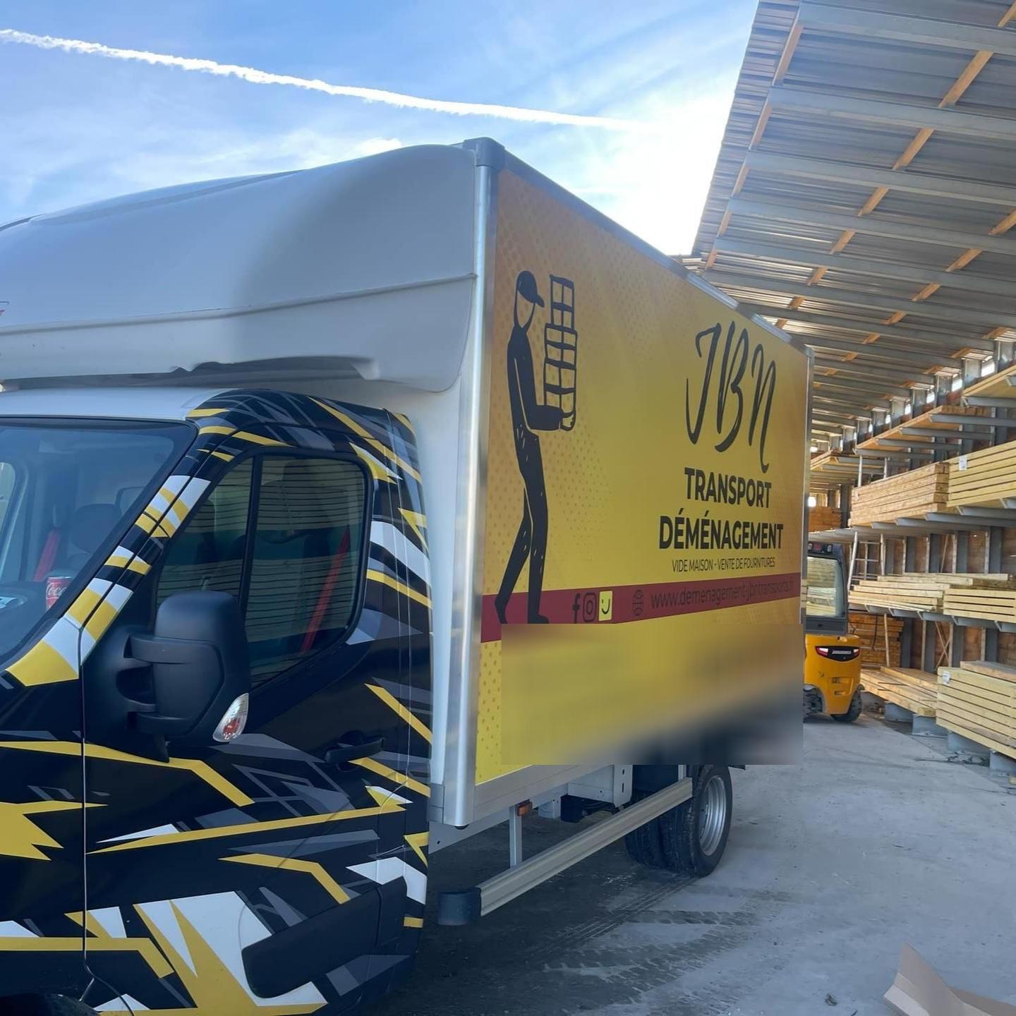 Camion de déménagement jaune et noir de JBN.