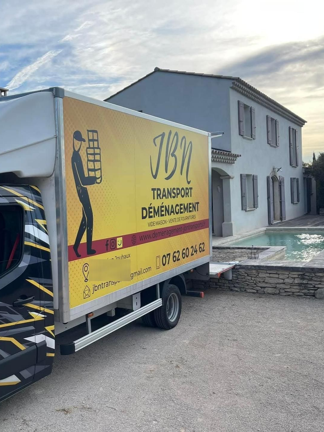 Camion de déménagement JBN Transport Déménagement stationné devant une maison.