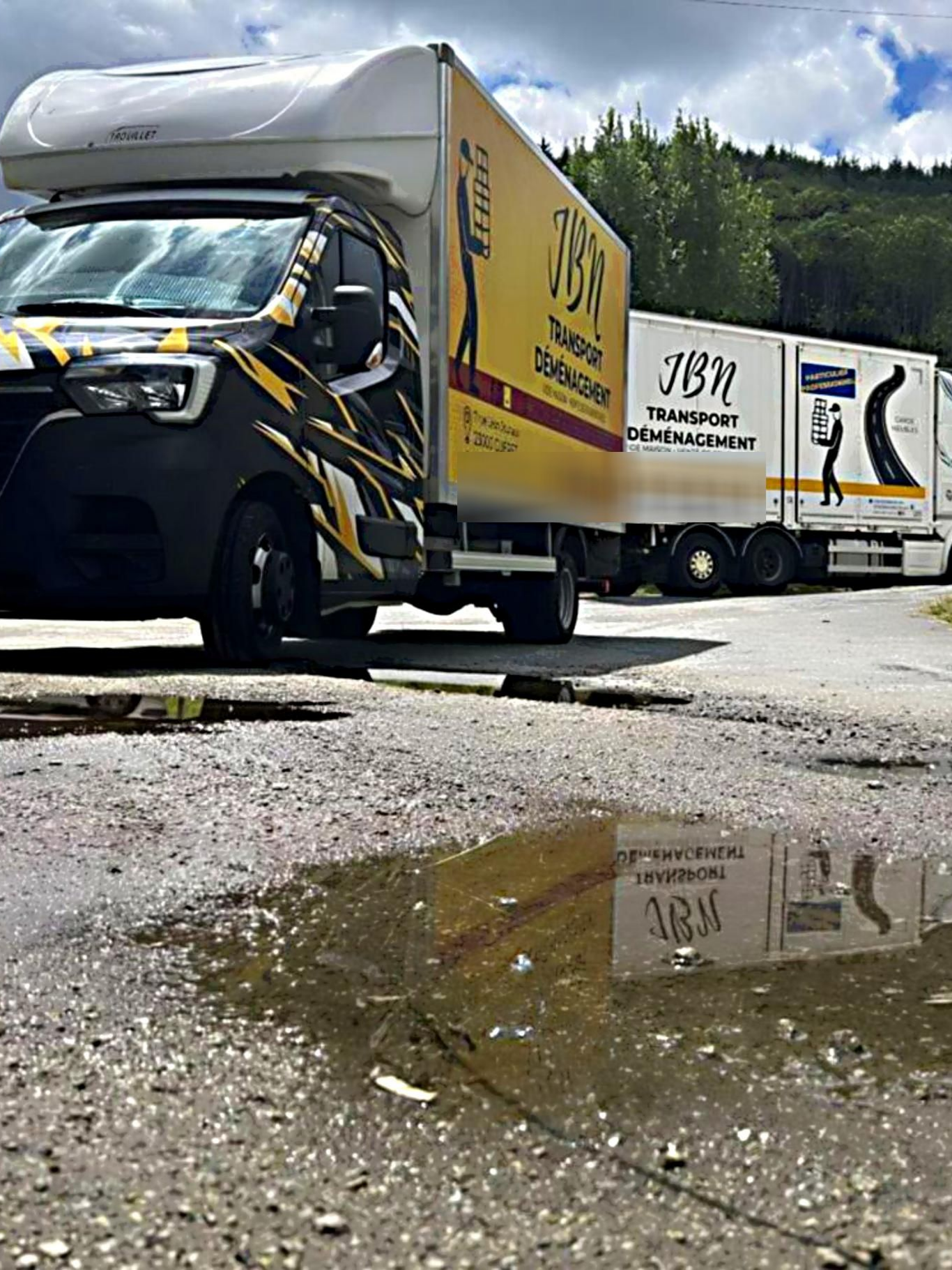 Plusieurs camions de la société JBN Transport sont stationnés sur une chaussée.