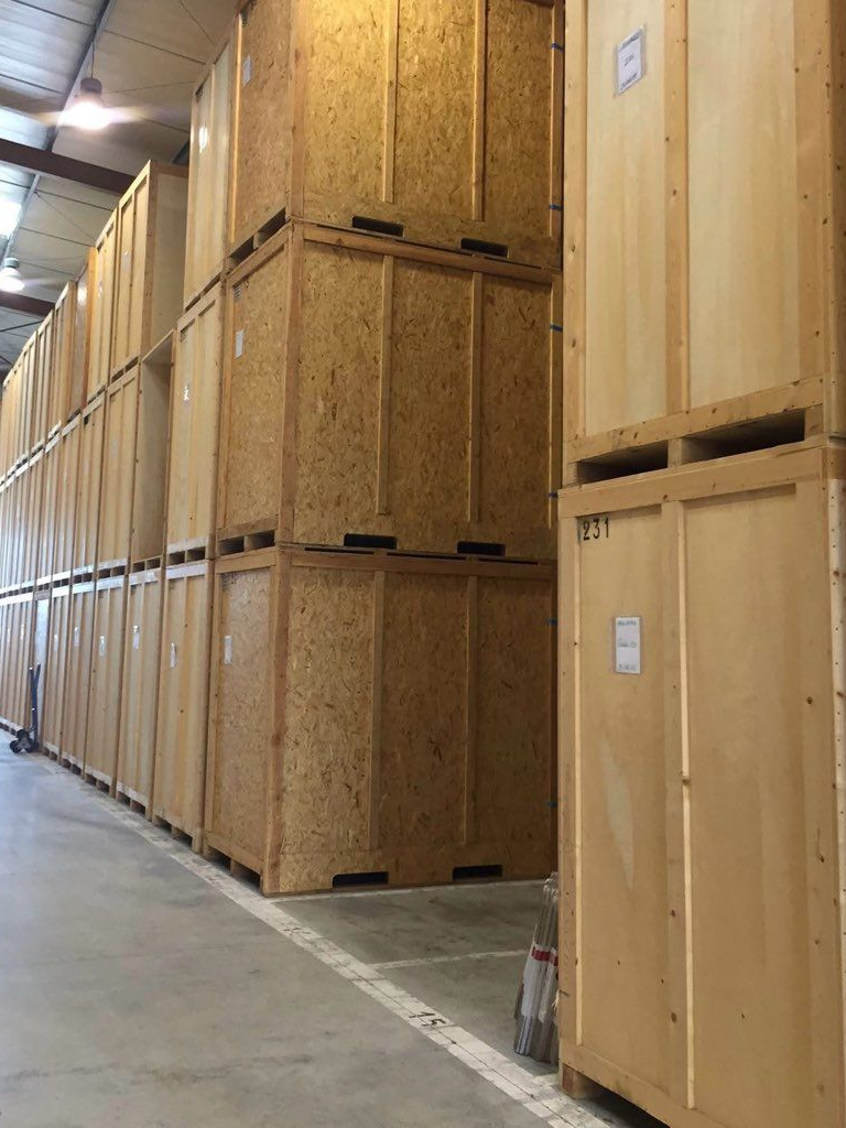 Rangées de conteneurs de stockage en bois empilés dans un entrepôt.