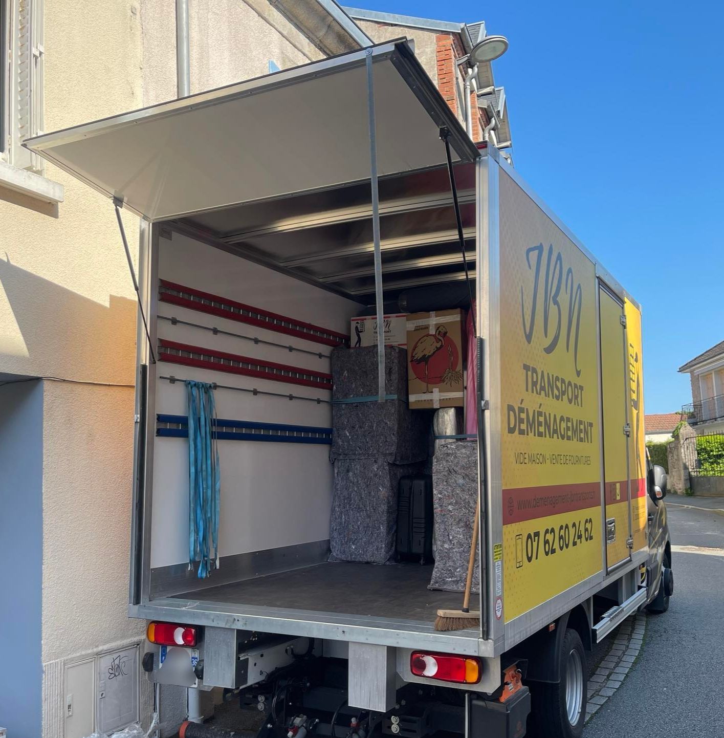 Deux camions de déménagement chargés de meubles sont stationnés.