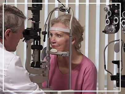 Examen ocular con paciente y optometrista en una lámpara de hendidura en una clínica.