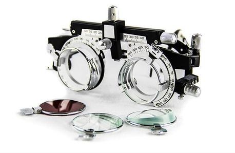 Tablero de muestra de monturas de gafas con lentes redondas plateadas y tintadas sobre fondo blanco.
