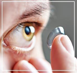 Lente de contacto sostenida cerca del ojo de la persona, lista para su inserción.