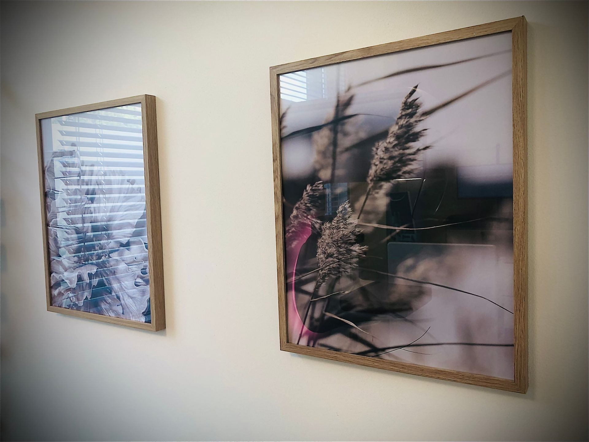 Zwei gerahmte Bilder hängen an einer weißen Wand