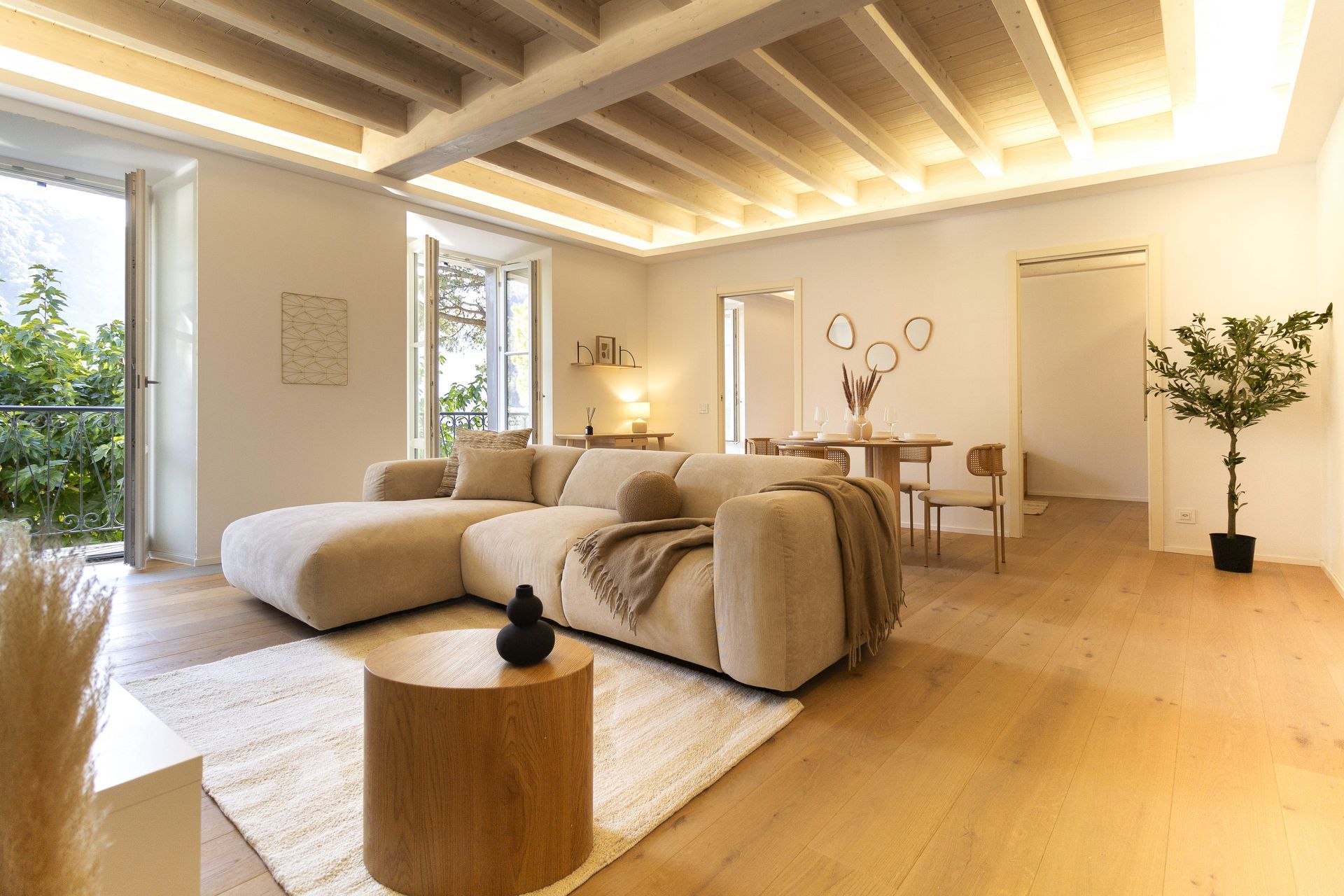 Salotto con divani, poltrone e tavolini blu, impreziosito da una parete geometrica e da un'illuminazione a globo.