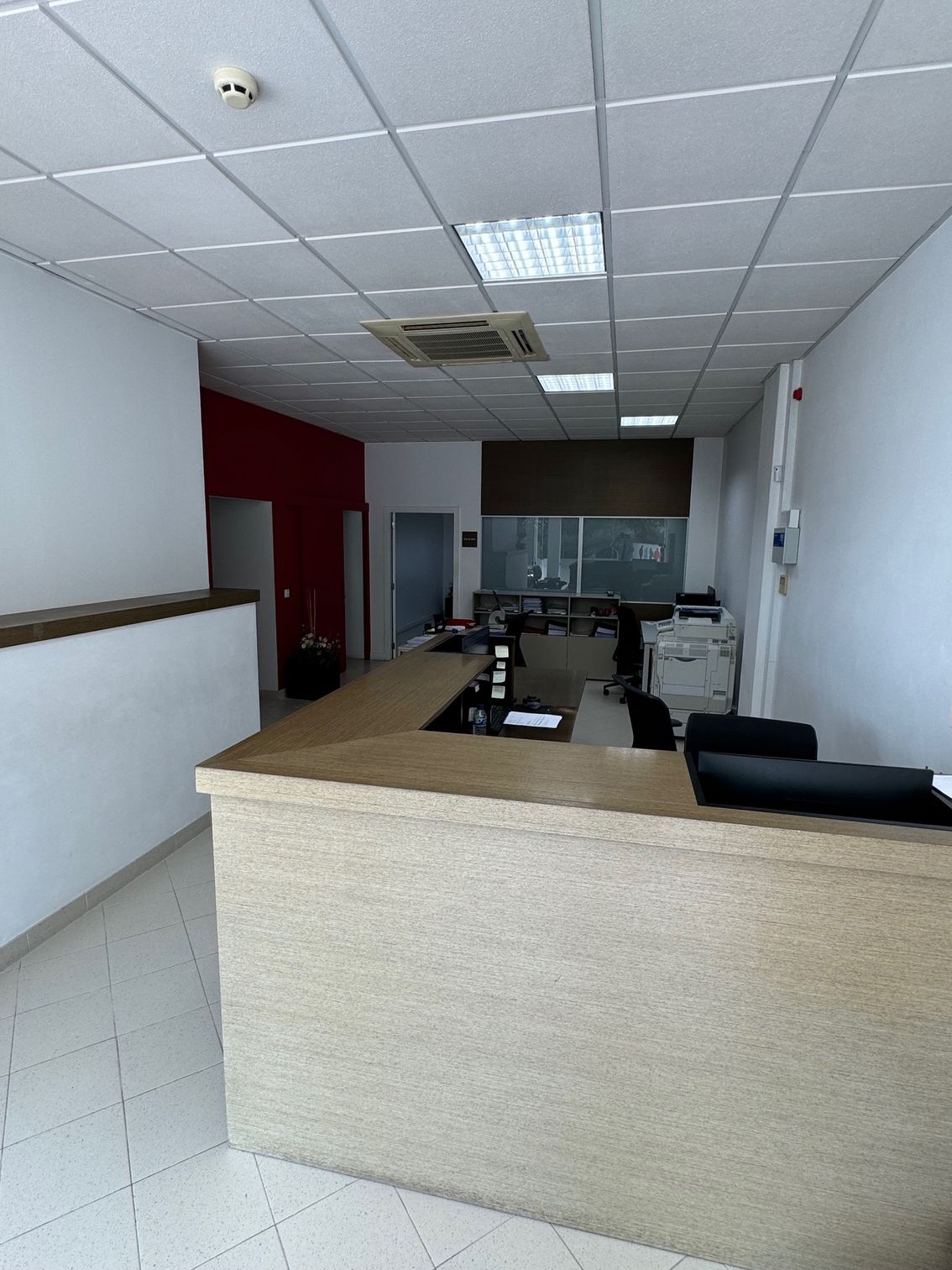 Um escritório vazio com uma mesa e uma impressora