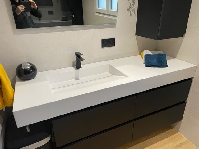 Un lavabo avec un meuble sombre