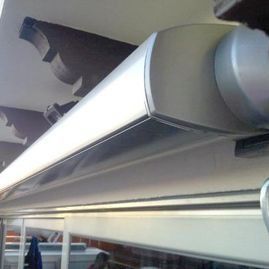 Primer plano de una pasarela de embarque metálica de un aeropuerto con un gran conducto redondo y una estructura superior.