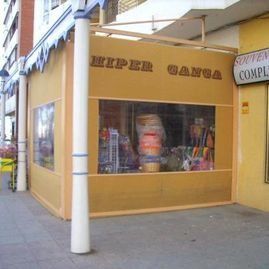 Tienda con fachada amarilla en la acera, con escaparate y letrero de “Reper Gang”.