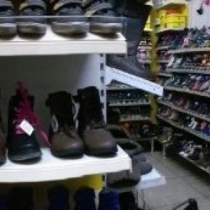 Schuhgeschäft mit Regalen voller Stiefel und Schuhe in verschiedenen Farben