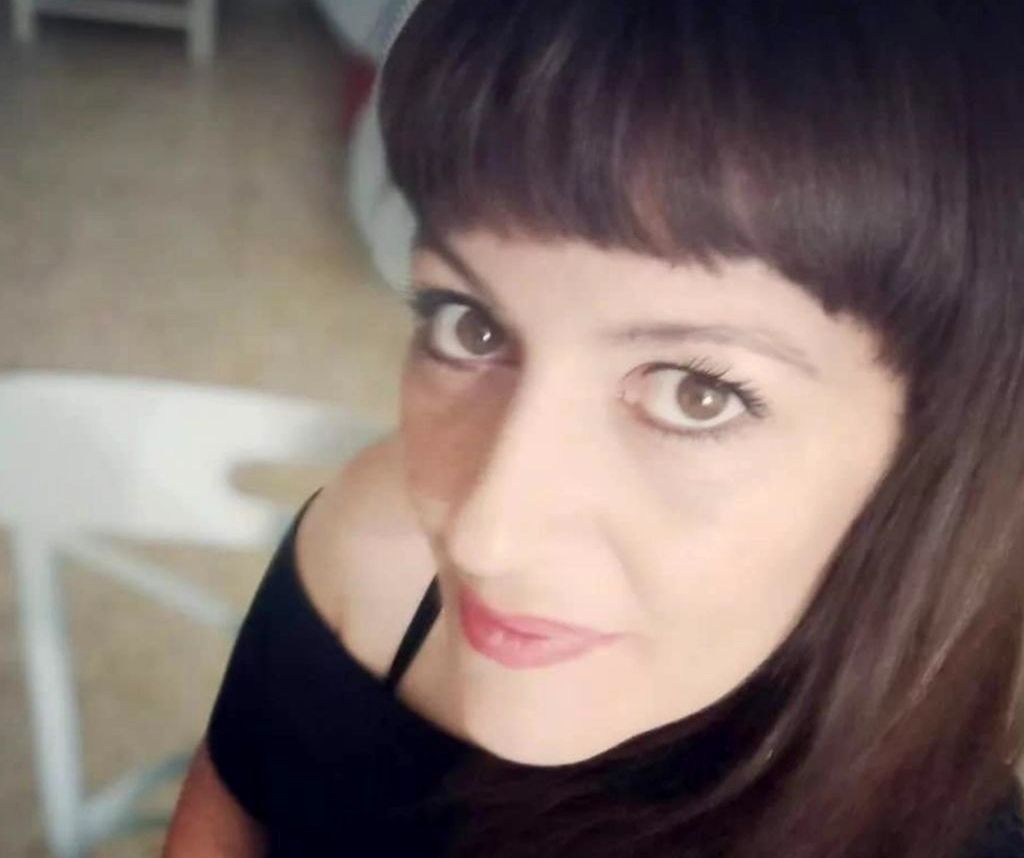 Un primer plano del rostro de una mujer con una silla blanca al fondo.