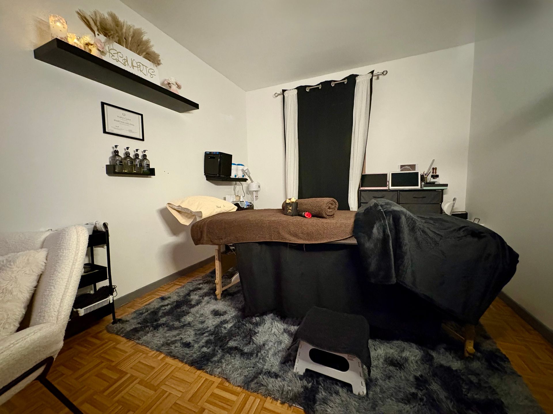 Un certificat encadré est accroché au-dessus d'une petite étagère noire.