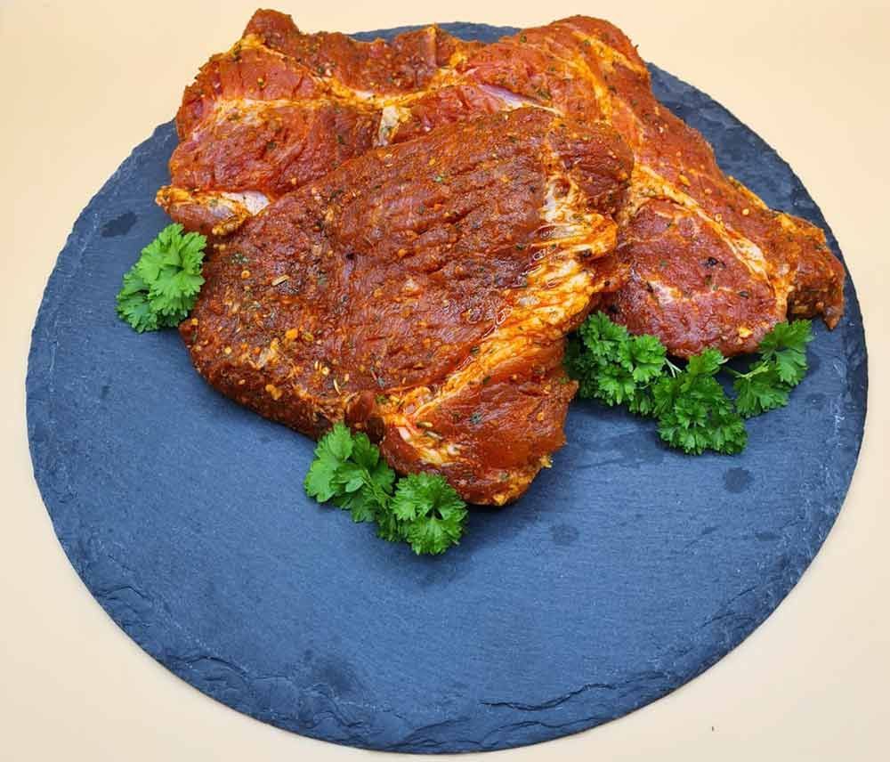 Ein Stück Fleisch liegt mit Petersilie auf einem Schneidebrett.