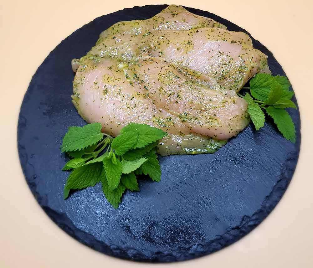 Ein schwarzer Teller mit Fleisch und Minzblättern