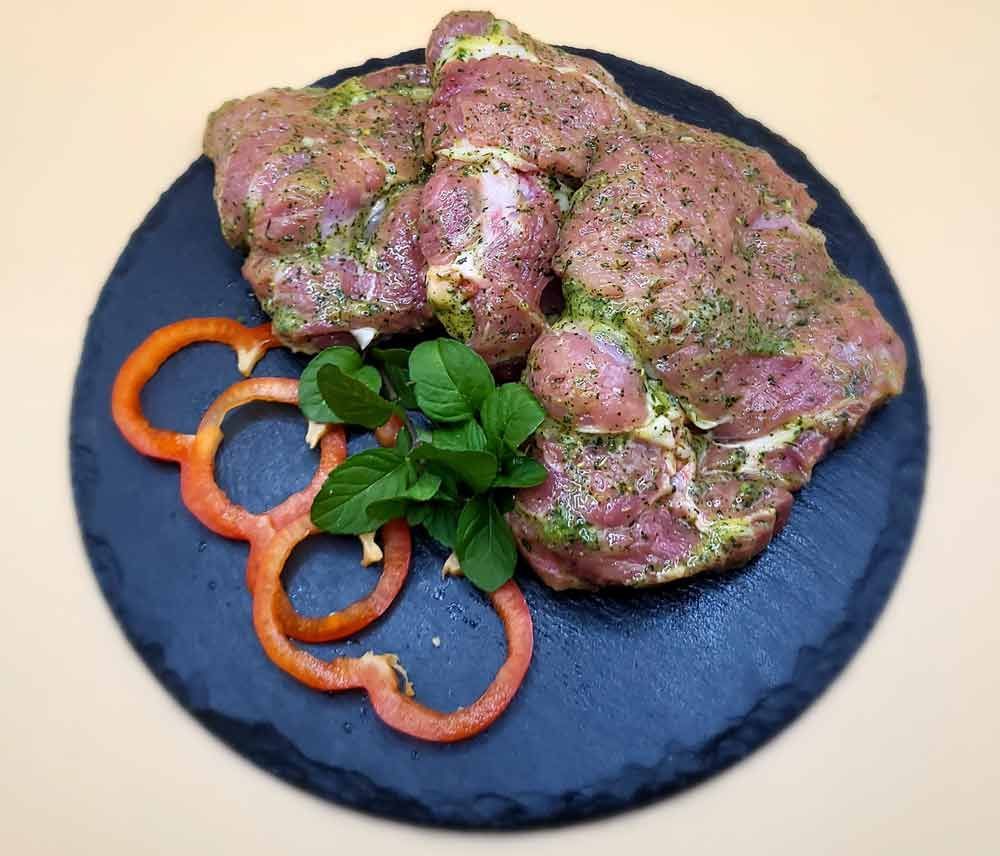 Ein schwarzer Teller mit Fleisch und Paprika auf einem Tisch