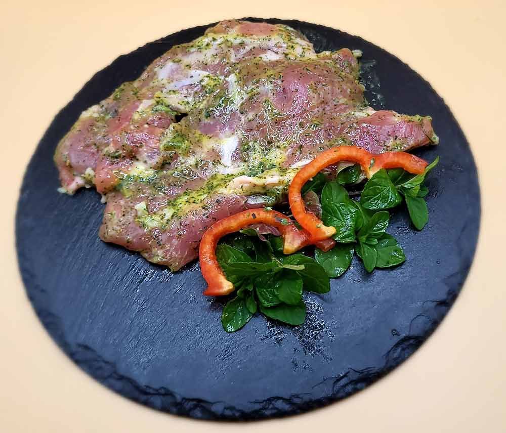 Ein schwarzer Teller mit Fleisch und Paprika darauf