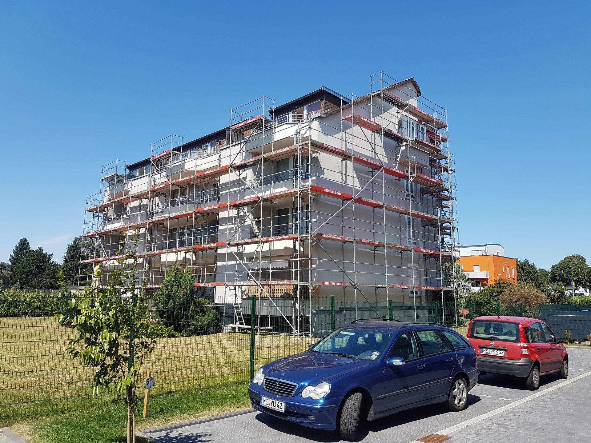 Neubau mit vollständigem Gerüst und Baukran.