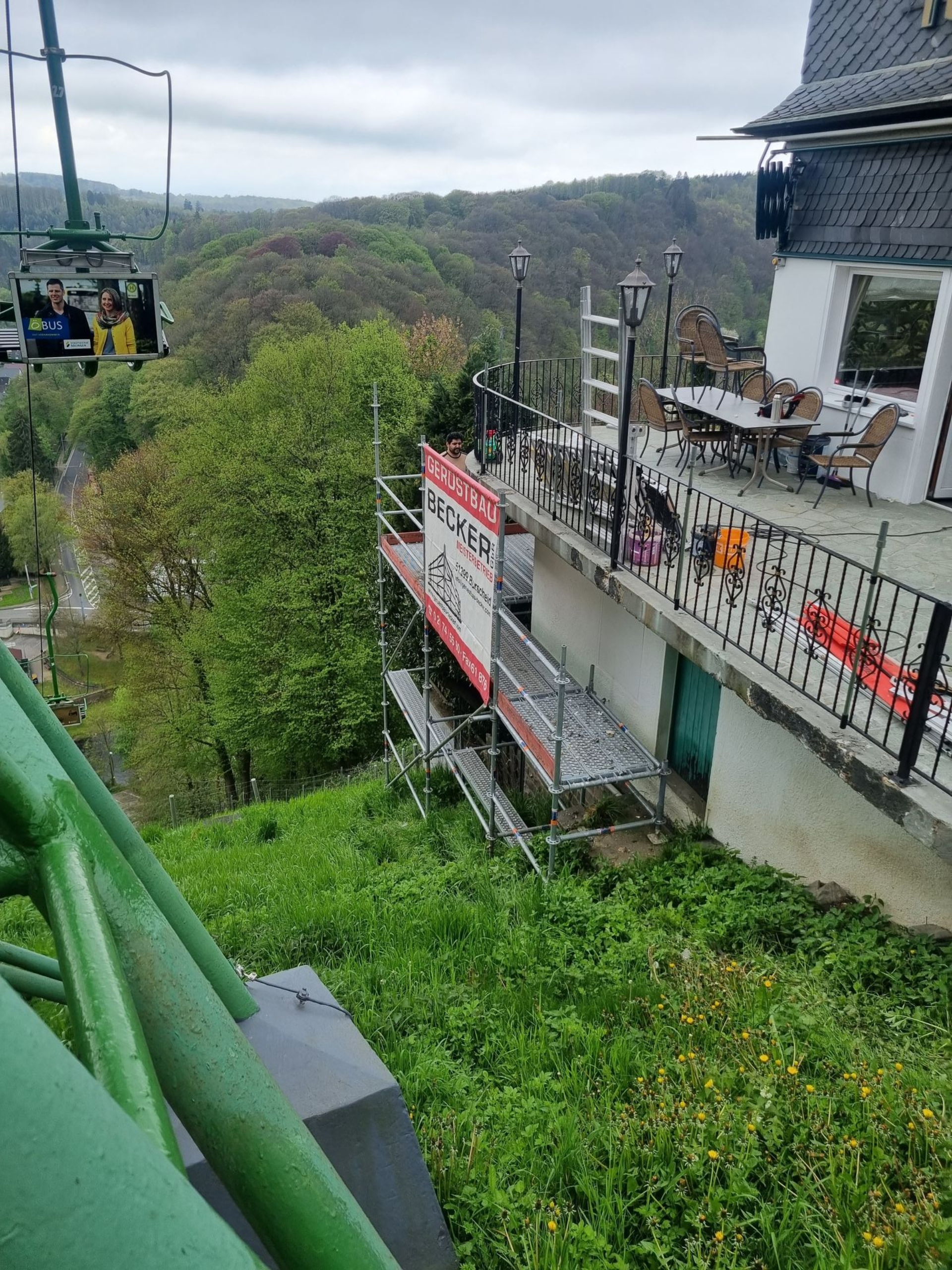 Eingerüstete Terrasse an Wohngebäude in Hanglage.