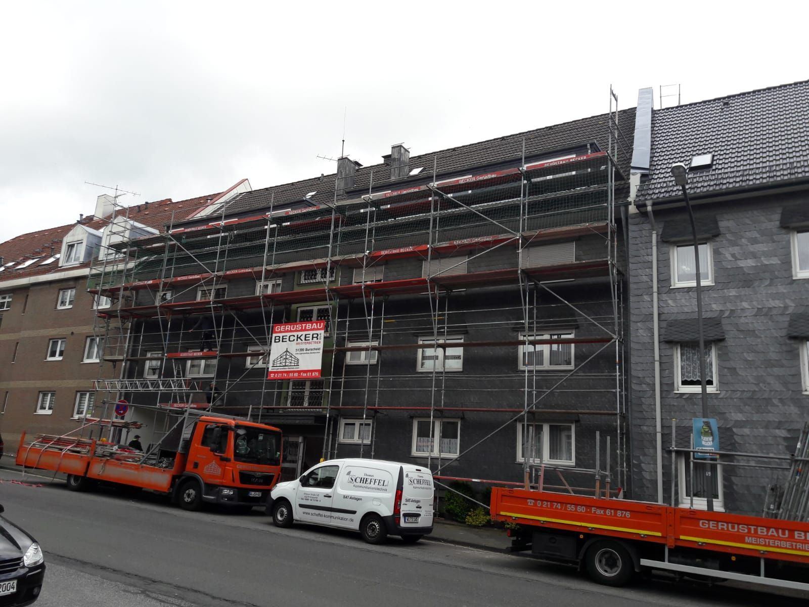 Mehrstöckiges Wohnhaus mit Fassadengerüst bei Sanierungsarbeiten.