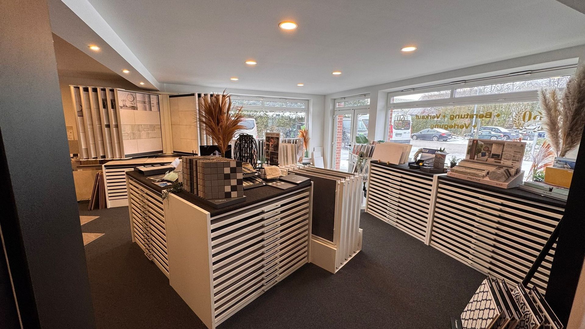 Innenansicht eines Ladens, in dem verschiedene Stoffe und Textilien mit schwarz-weiß gestreiften Akzenten 