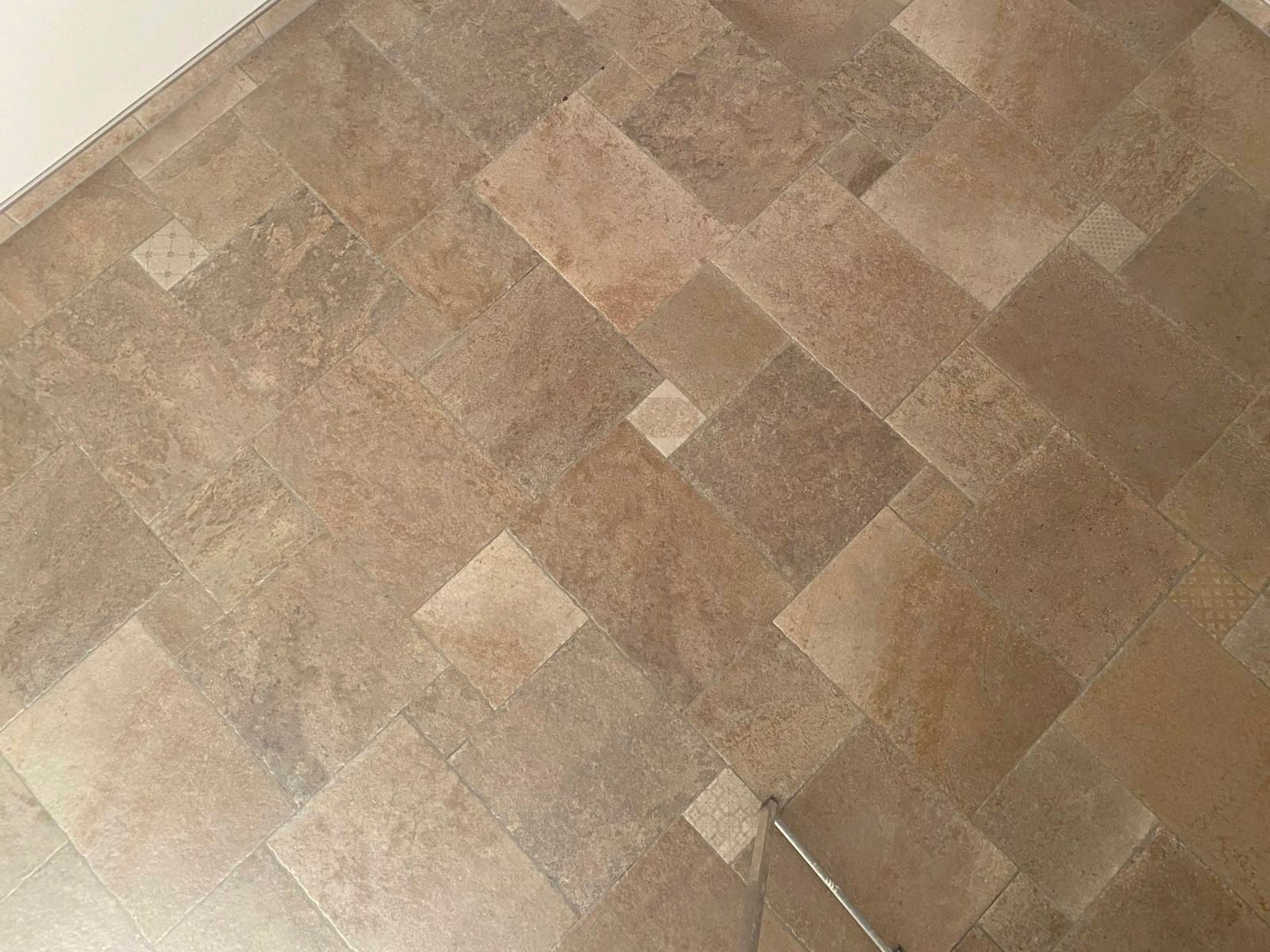 Brauner Fliesenboden mit geometrischem Muster.