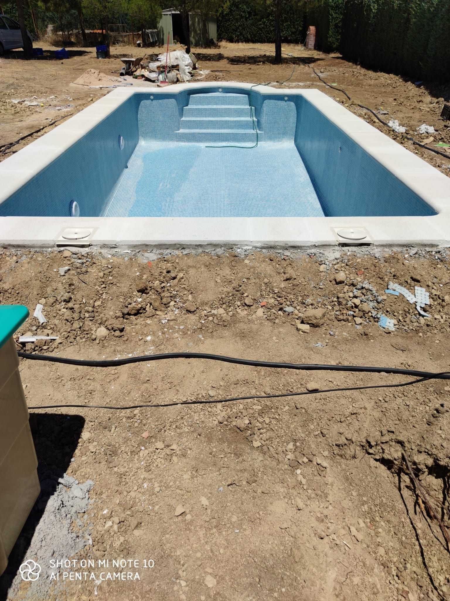Se está construyendo una gran piscina en un campo de tierra.
