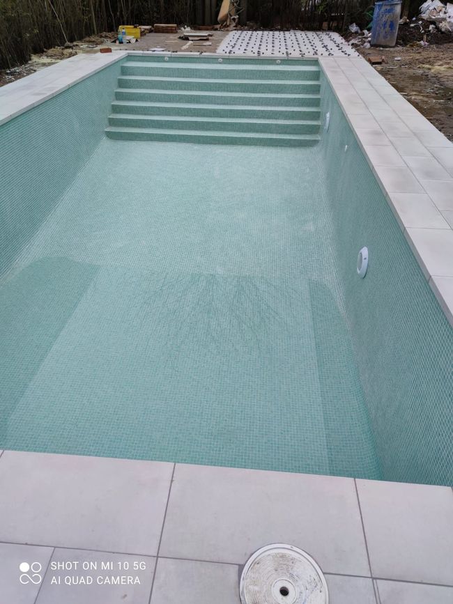 Una gran piscina con escaleras que la rodean.