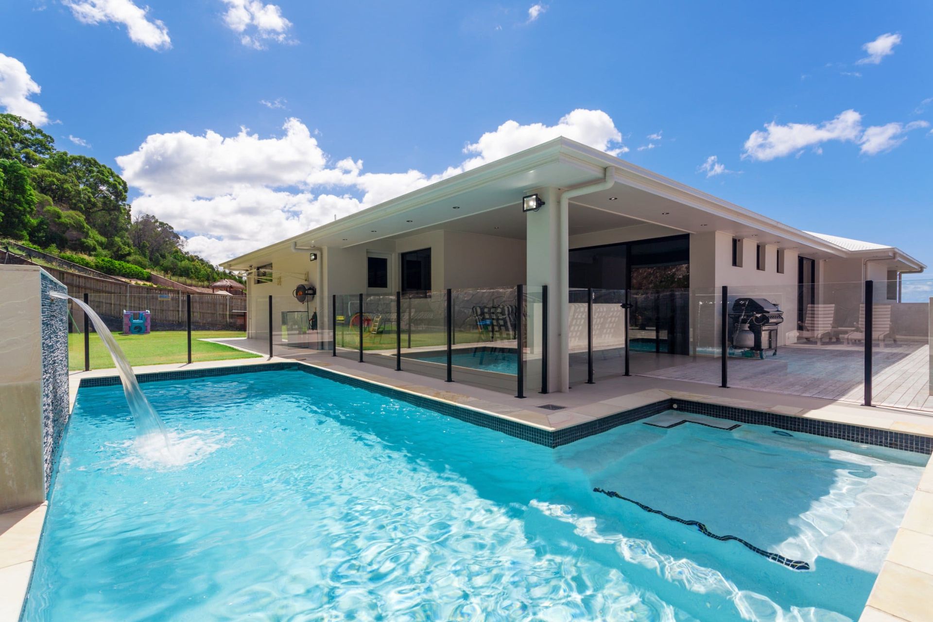 Hay una gran piscina delante de una casa.