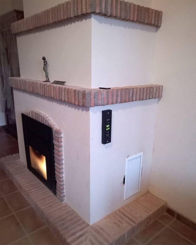 Una chimenea en la esquina de una habitación con una estatua encima.