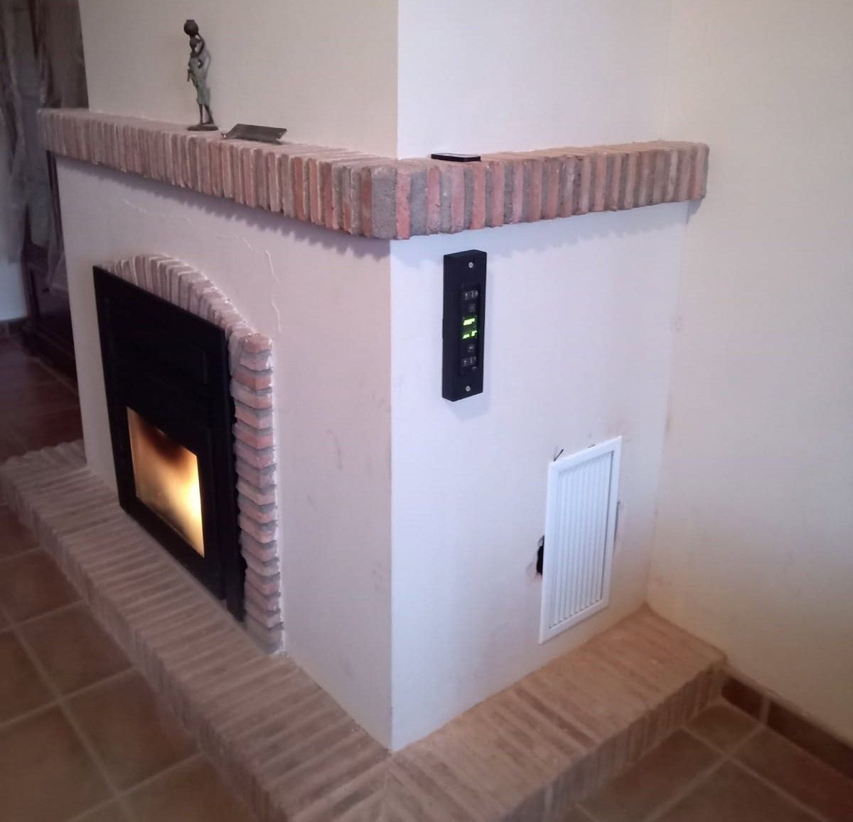Una chimenea con una estatua encima