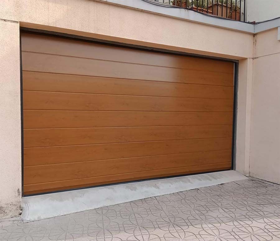 Una puerta de garaje de madera está situada en el costado de un edificio.