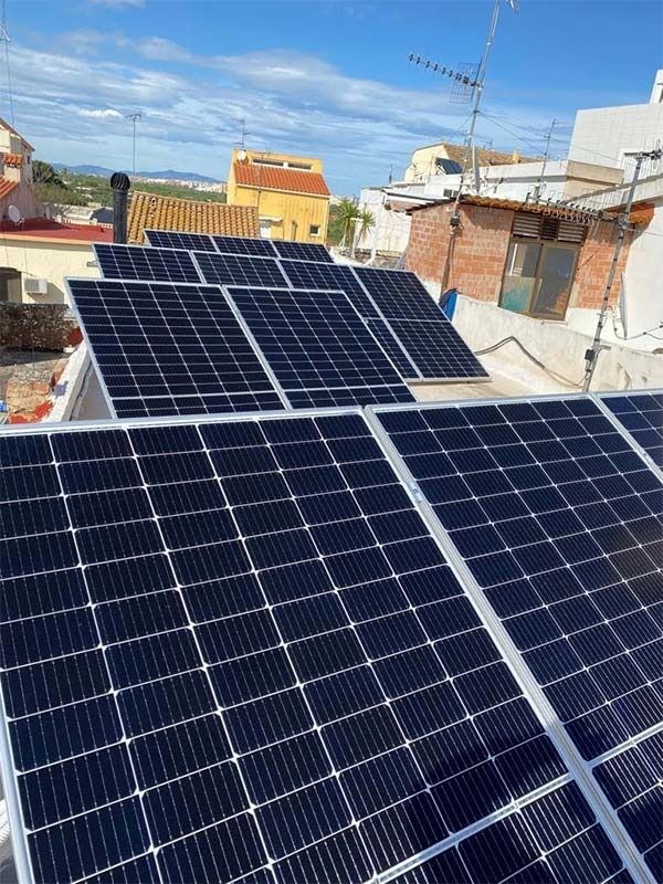 Un montón de paneles solares están colocados encima de un tejado.