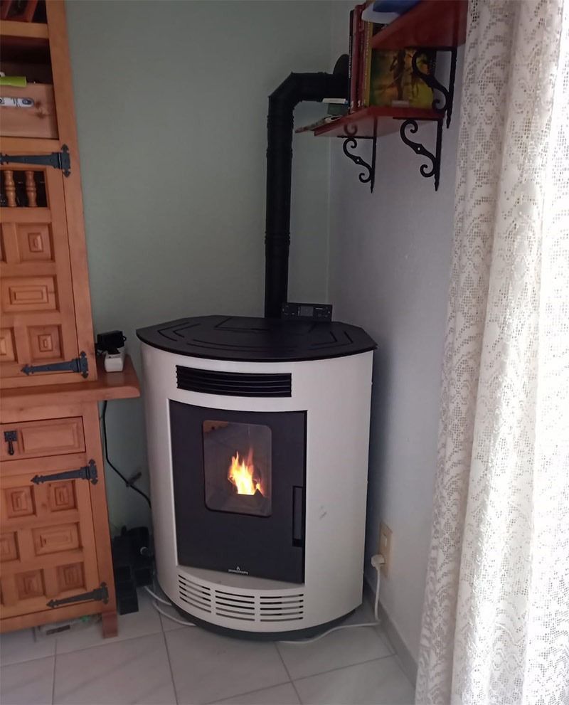 Una estufa blanca está en la esquina de una habitación.