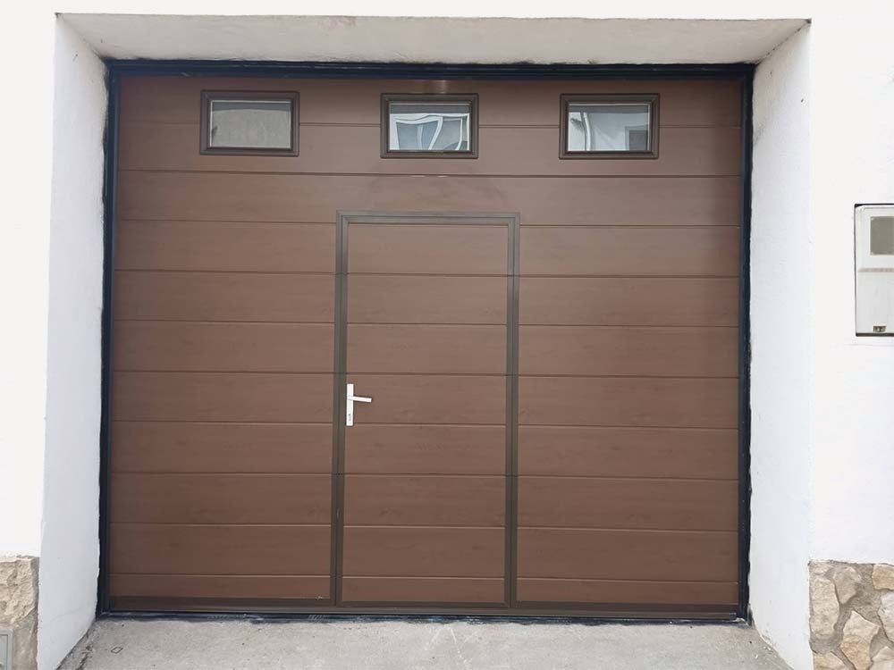 Una puerta de garaje marrón con manija blanca