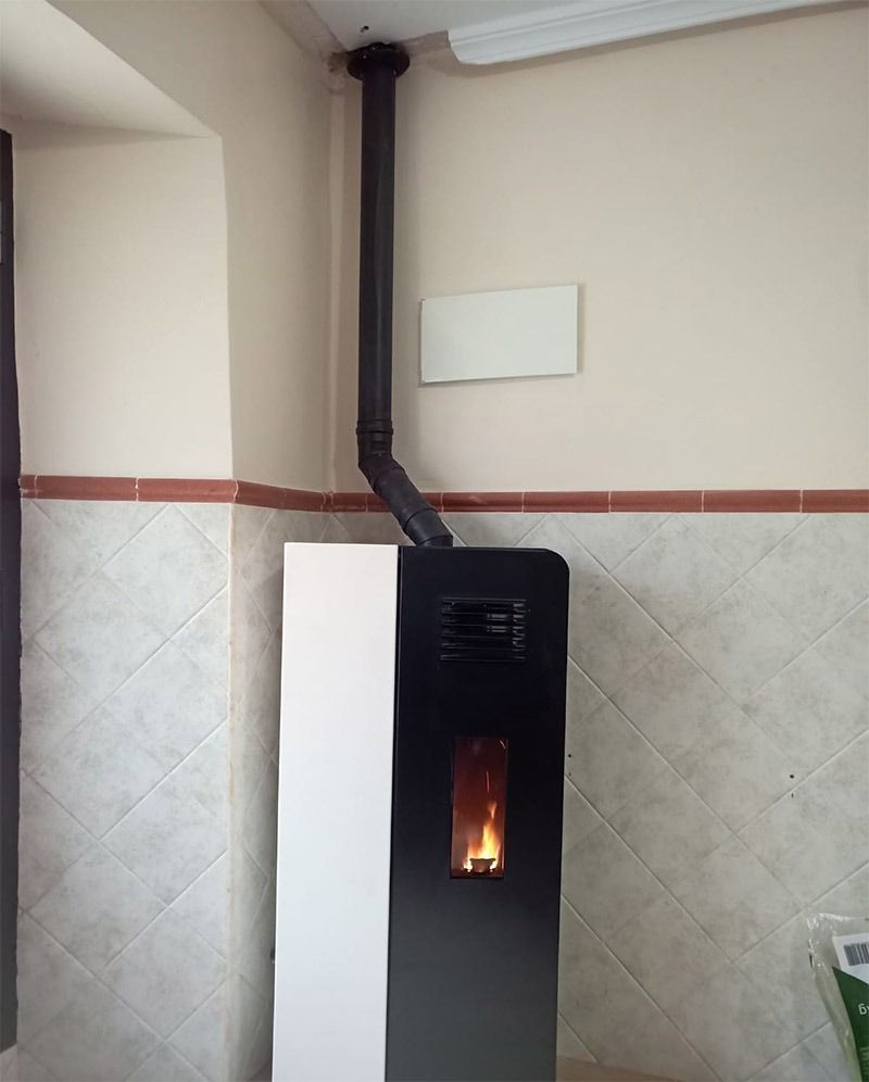 Una estufa en blanco y negro con una chimenea adjunta.