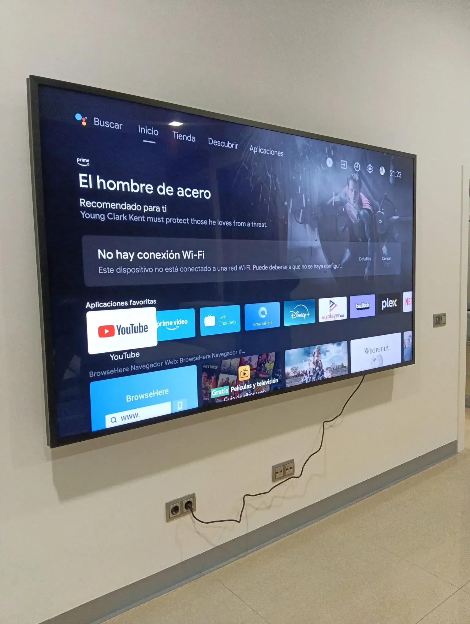 Televisor grande montado en una pared blanca, que muestra un servicio de transmisión.