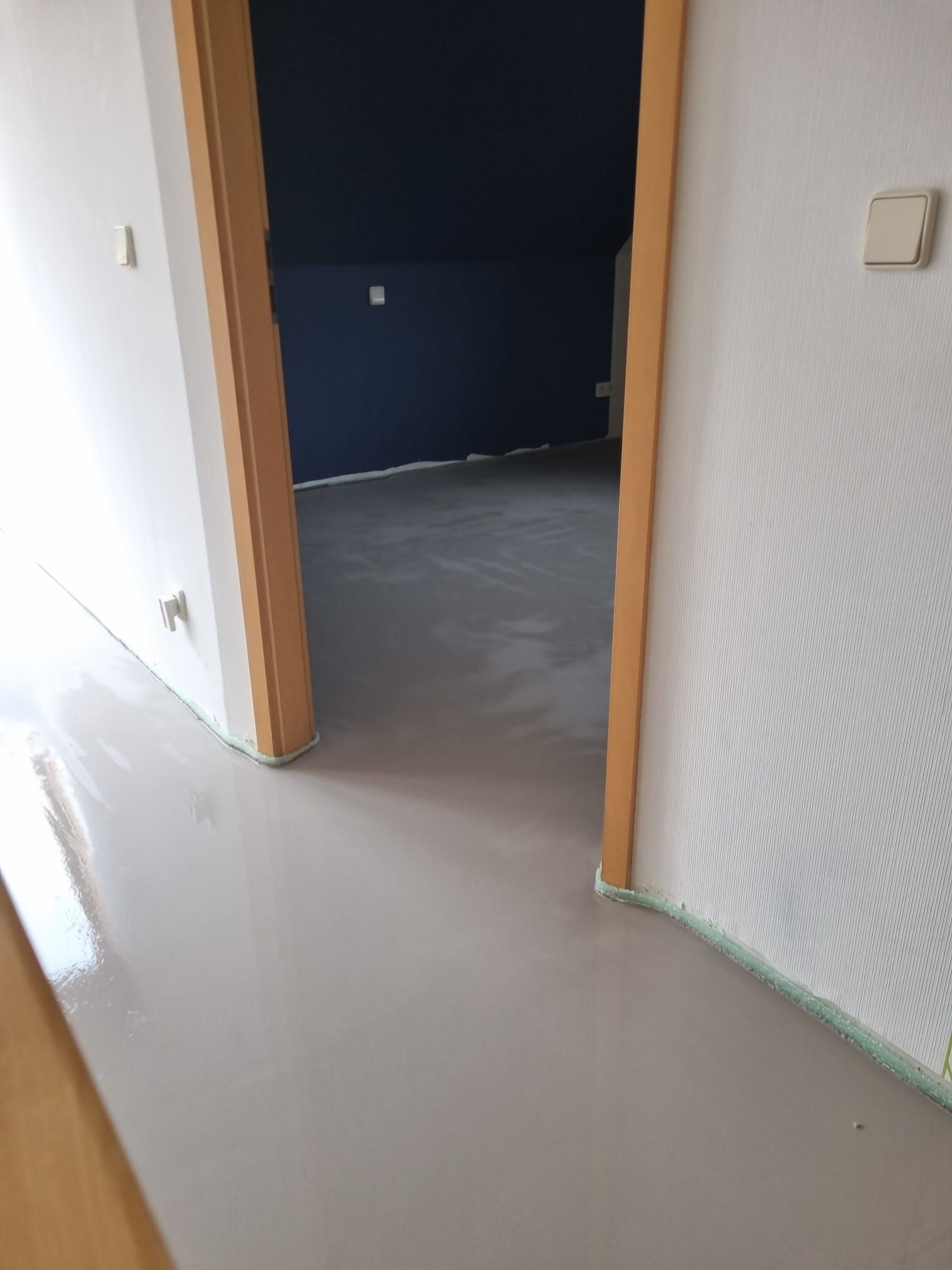 Ein Flur mit einer Tür, die zu einem Zimmer führt.